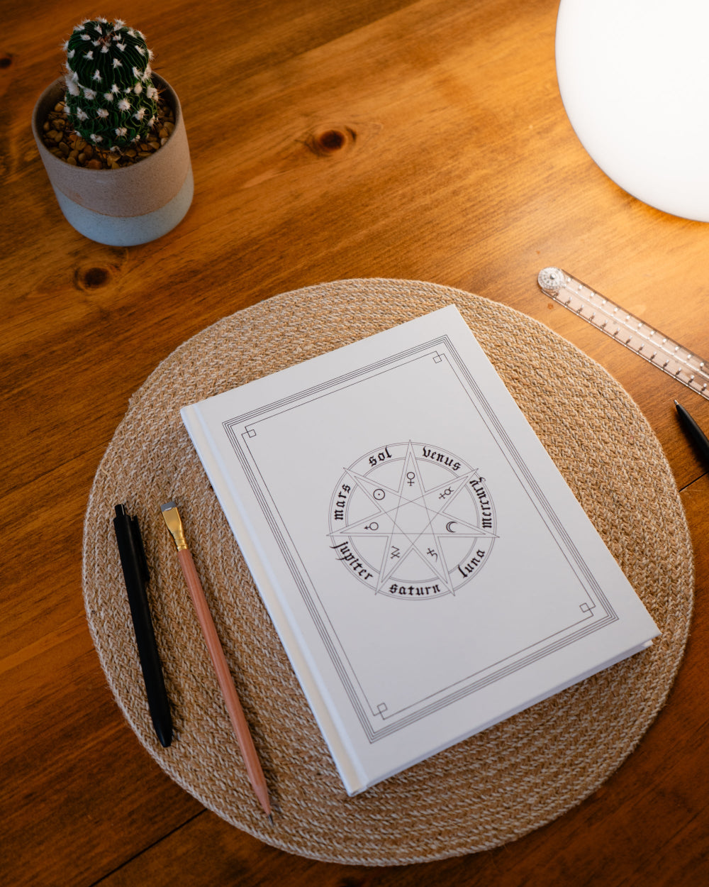 Notebook with astrological design on a wooden table with stationery items