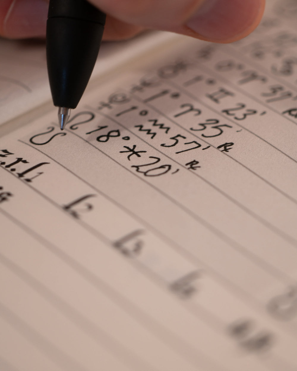 Hand writing on a notepad with a pen