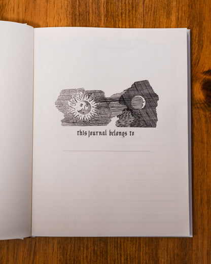 Open journal with decorative cover on a wooden surface